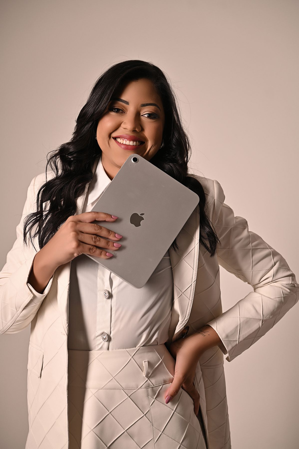 Jessyka Dumont segurando um tablet, de blazer claro